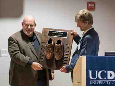 Axel Borg (left) holds the Nash Prize plaque with Flagg Miller (right), chair of the Nash Prize Selection Committee. The bronze shoes celebrate those who, like Borg, have followed in Nash’s footsteps. (Photo by Fred Greaves)